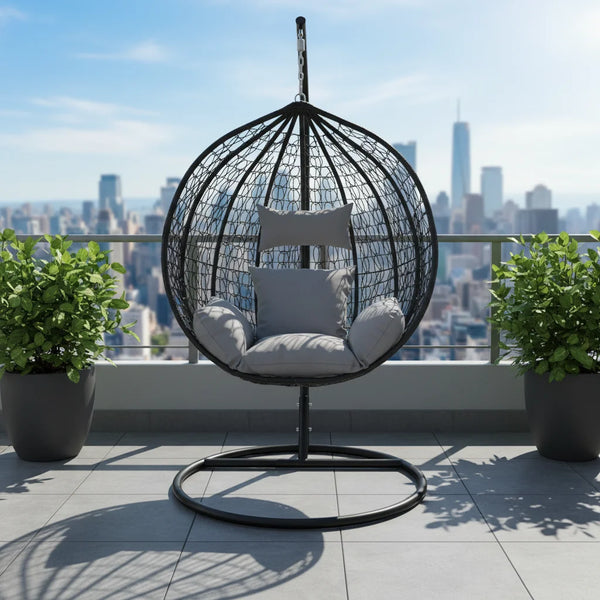 Stylish Modern Indoor-Outdoor Swing Chair on a balcony with city skyline view and green plants.