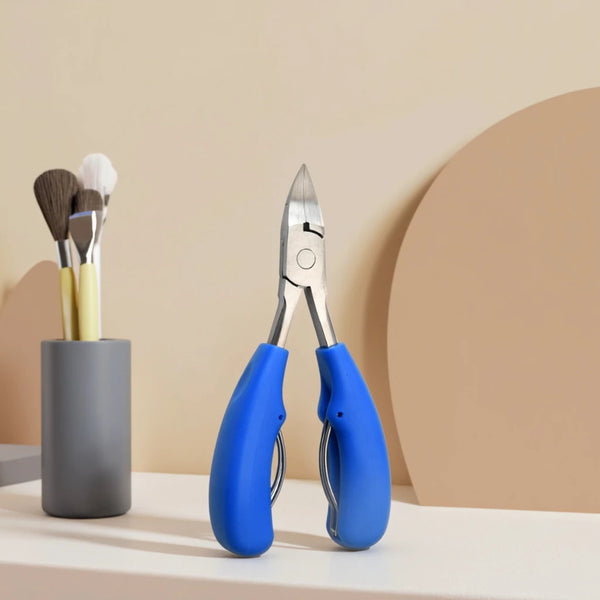 Professional Nail Cutter Nipper for Thick Nails on a table with brushes in the background