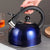 Stainless Steel Whistling Flat Bottom Kettle with black handle on a kitchen counter.