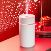The Mini 420ml USB Air Humidifier emitting mist against a decorated red background, perfect for improving air quality.