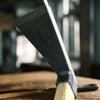 Carbon Steel Wooden Handle Garden Hoe next to a wooden surface, showcasing its durable design for garden maintenance.