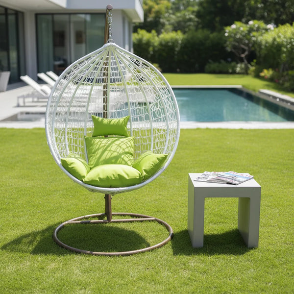 Modern Indoor-Outdoor Swing Chair on green grass near a pool, featuring a round design and vibrant cushions.