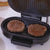 Home Mini Panini Sandwich Machine grilling two beef patties on a countertop.