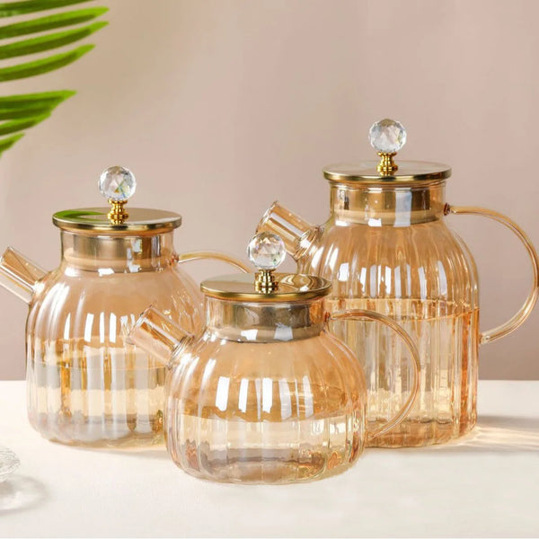 Elegant Large Capacity All-Glass Tea Set featuring three glass teapots with gold accents on a stylish table.