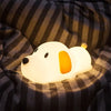 The Lumipets Puppy Night Light resting on a cozy blanket, providing a soft glow for bedtime comfort.