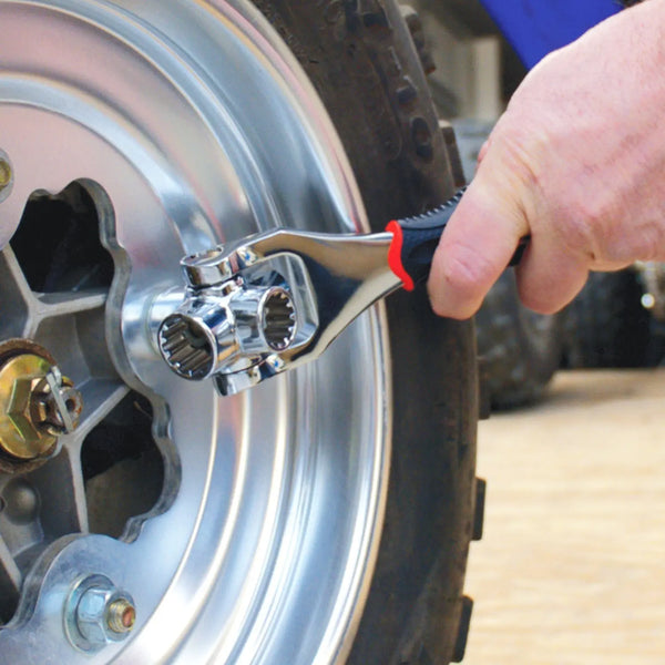 Person using a 52-in-1 Multi-function Socket Wrench on a wheel for tightening bolts.