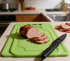 Mini Kitchen Chopping Board with Knife, featuring sliced meat on a green board with a black knife in a kitchen setting.