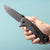G10 Stainless Steel Folding Hunting Knife held in hand, showcasing its sleek design and sharp blade.