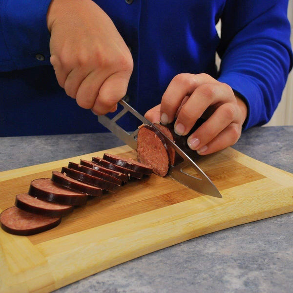 Person slicing sausage on a cutting board using the Aero Knife, highlighting its precision and sharpness.