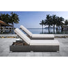 Outdoor Garden Lounge Daybed Wicker Deck Bed with white cushions by a poolside surrounded by palm trees.