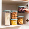 Dry Food Storage Container with Lid holding various dry pantry staples like pasta, nuts, and snacks in organized cupboard.
