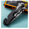 G10 Stainless Steel Folding Hunting Knife resting on a green surface next to its packaging.