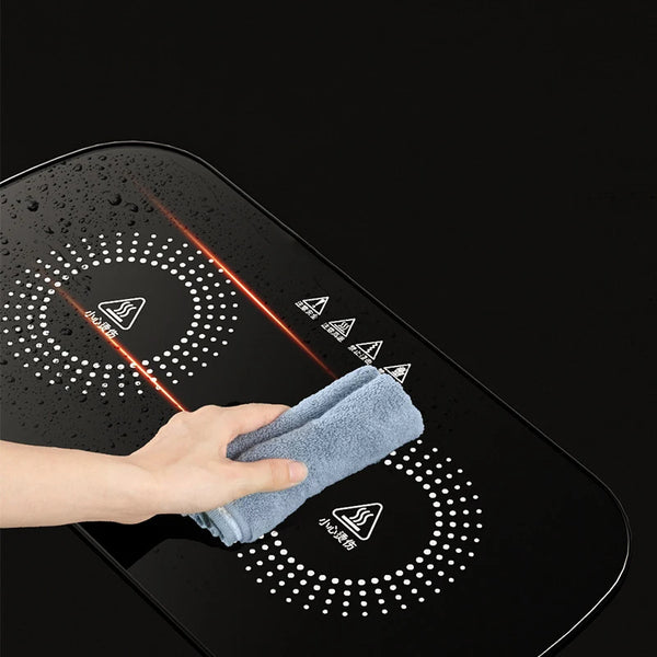 Cleaning the surface of a Portable Electric Food Warming Tray with a cloth to maintain hygiene and shine.