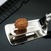 Stainless Steel Steak Clip Food Tong holding a walnut on a grilling surface for cooking and serving.