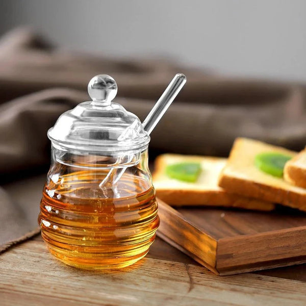 Hand-Blown Bee-Shaped Borosilicate Glass Honey Jar with honey and toast in the background.