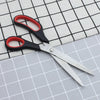 11-inch Stainless Steel Clothing Scissors resting on a grid-patterned fabric for precision cutting.