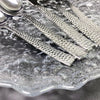 5-Piece Silverware Set displayed on a textured glass plate with detailed silver handles.