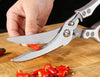 Chicken Shredder Tool: Hand using scissors to cut fresh red chili peppers on a wooden cutting board.