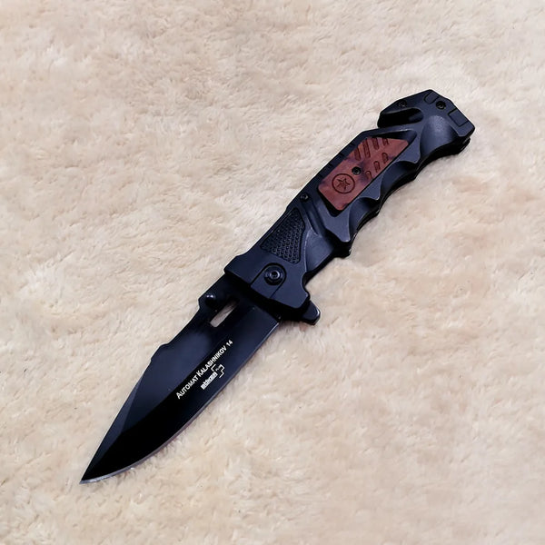 Non-Slip Stainless Steel Folding Meat Knife with a sleek black design on a soft surface.