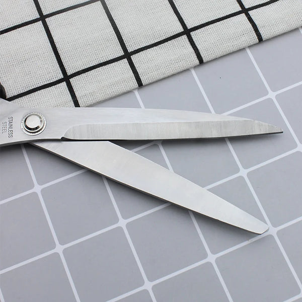 Close-up of 11-inch Stainless Steel Clothing Scissors on a checkered fabric background.