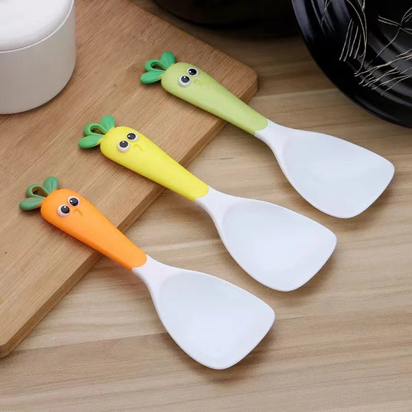 Creative Carrot Plastic Rice Scoop in three vibrant colors on a wooden surface, perfect for reducing mess during meals.