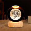 Crystal Milky Way LED Globe – 6 cm showcasing a detailed moon design with a wooden base emitting soft light.