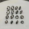 A collection of stainless steel double pipe clamps showcasing various sizes and designs for securing pipes and hoses.