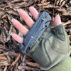 4-Function Portable Stainless Steel Survival Knife in hand on dry leaves background.