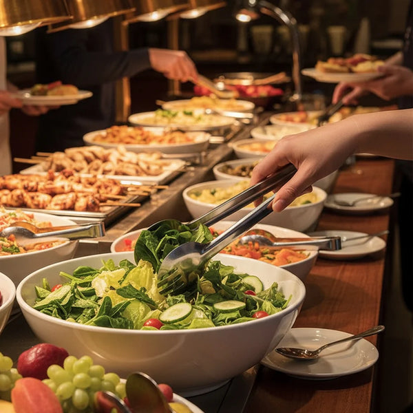 A person using a Stainless Steel Small Food Clip to serve a fresh salad at a buffet.