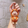 Super Cute Rotatable Head Capybara Keychain held in hand, featuring adorable capybara figure in an orange hoodie.