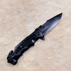 Non-Slip Stainless Steel Folding Meat Knife on a soft surface, highlighting its sleek design and sharp blade.