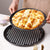 Non-Stick Carbon Steel Baking Cake Mold with freshly baked pizza on top, showcasing its non-stick properties.
