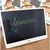 LCD Writing Tablet Drawing Board with colorful handwriting on screen, ideal for kids' creativity and learning.