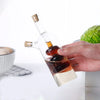 2 in 1 Olive Oil Vinegar Bottle Dispenser held in hand with dark and light liquids for kitchen use.