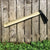 Carbon Steel Wooden Handle Garden Hoe against a wooden fence with green foliage below.