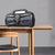 Portable Bluetooth Outdoor Speaker with LED Display on a wooden table.