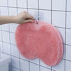 Hand reaching for the Non Slip Shower Foot Scrubber Massager mounted on a bathroom wall.