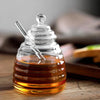 Hand-Blown Bee-Shaped Borosilicate Glass Honey Jar with honey and dipper on wooden table