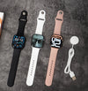 S11 Smart Watch Fitness Tracker in black, white, and pink with charging cable on a gray background.