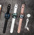 S11 Smart Watch Fitness Tracker in black, white, and pink with charging cable on a gray background.