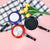Non Stick Aluminum Mini Round Frying Pan collection in various colors on a checkered cloth with tulips.