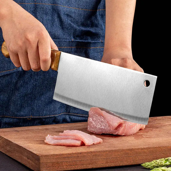 Person using a Heavy Duty Stainless Steel Bone Chopping Butcher Cleaver on a cutting board with meat.