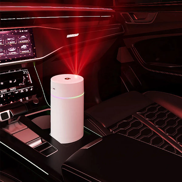 The Mini 420ml USB Air Humidifier on car center console with colorful mist and stylish design.