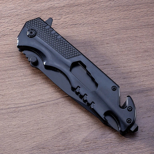 Iron Grip Full Metal Survival Folding Knife resting on a wooden surface, showcasing its sleek design and rugged features.