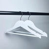 Boutique Wooden Kids Clothing Hanger displayed on a black rod, showcasing its sleek and stylish design for children's garments.