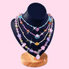 DIY Girls Bracelet Making Kit with Beads & Charms featuring colorful necklaces displayed on a stand.