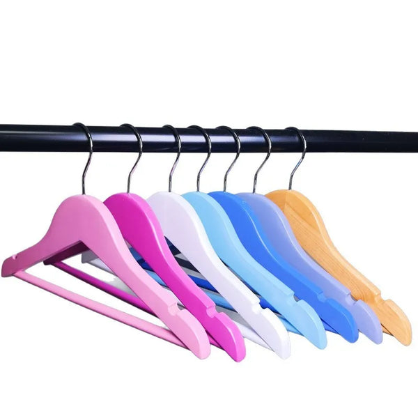 Boutique Wooden Kids Clothing Hanger in pink, white, blue, and yellow hanging on a rack.