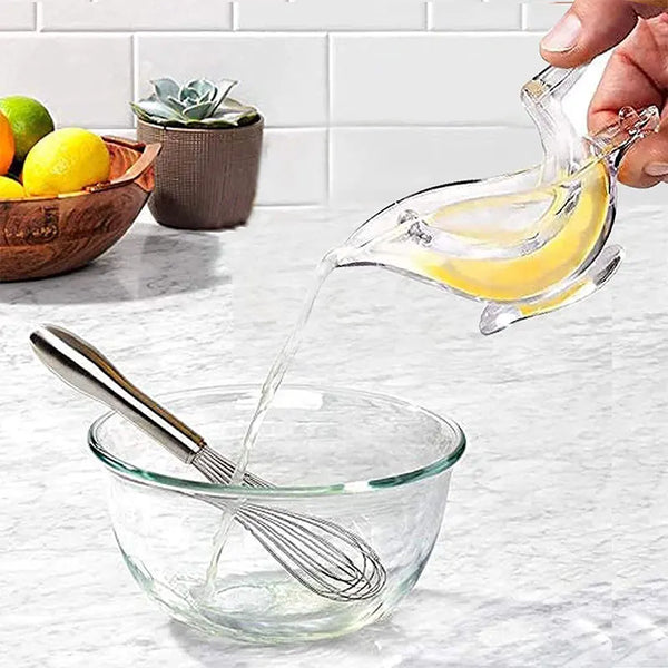 Bird-Shaped Acrylic Manual Lemon Squeezer pouring fresh lemon juice into a glass bowl with a whisk.