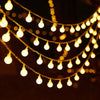 Bubble Ball Fairy String Lights glowing softly across a dark background with warm yellow light accents.