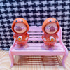 Super Cute Rotatable Head Capybara Keychain figures on a pink bench, showcasing adorable designs and charm.